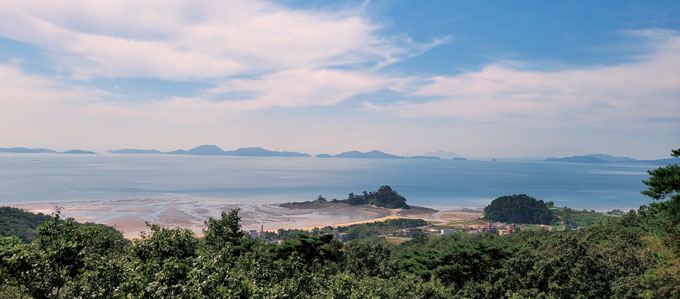 국사봉 임도에서 바라본 장골해변과 독바위. 멀리 승봉도, 대이작도, 소이작도, 덕적도가 조망된다.